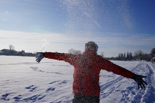 eine Frau wirft Schnee in die Luft